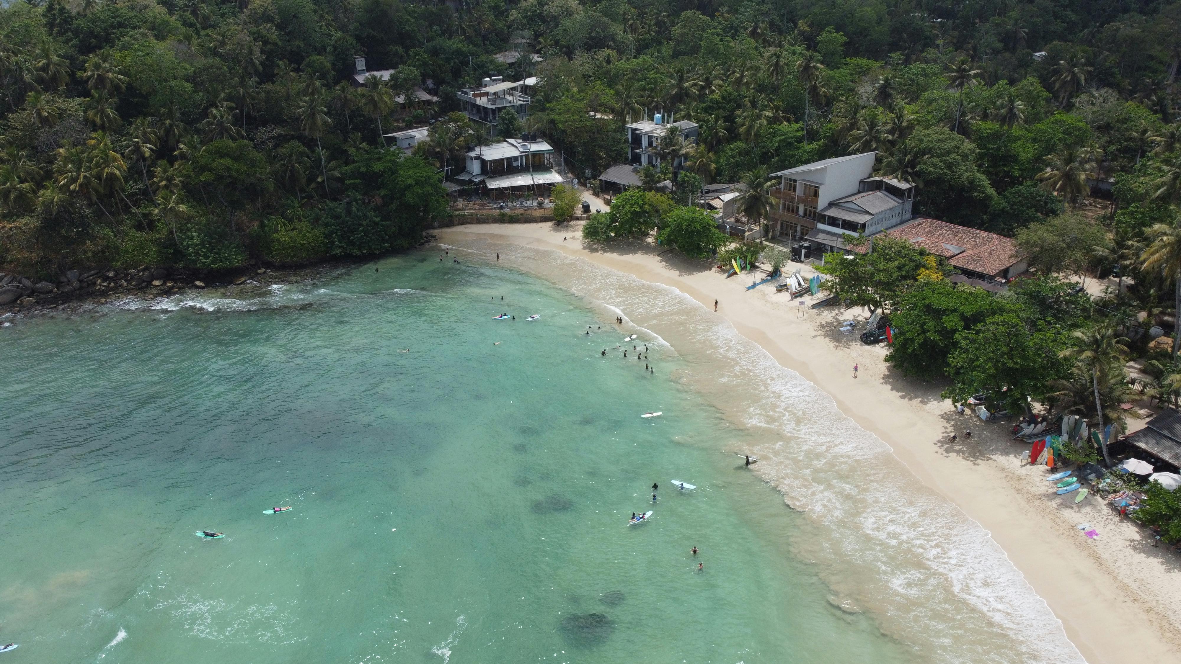 Aerial view of Hiriketiya horseshoe bay with surfers, Sri Lanka